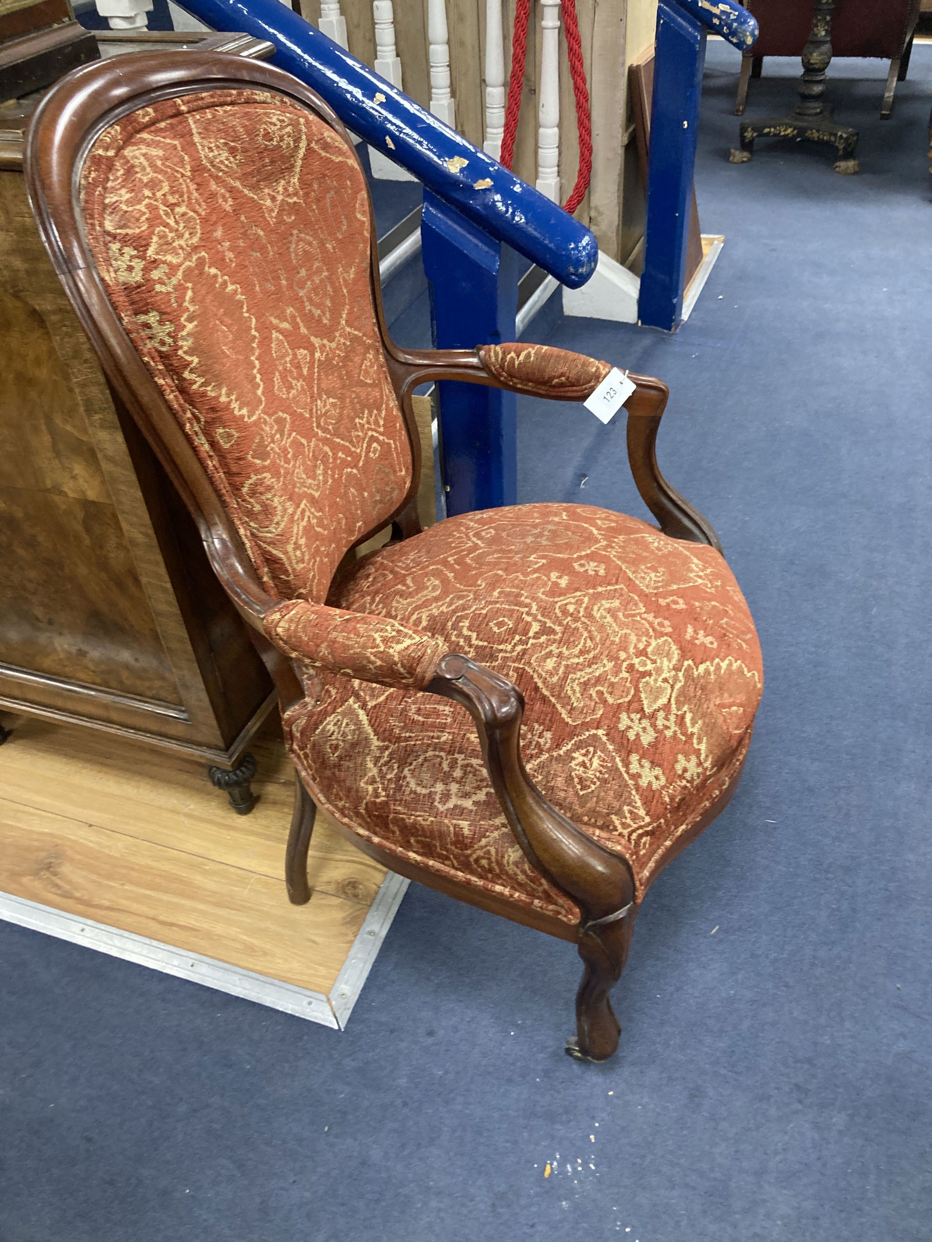 A Victorian mahogany upholstered spoon back upholstered elbow chair, 95cm high, width 63cm